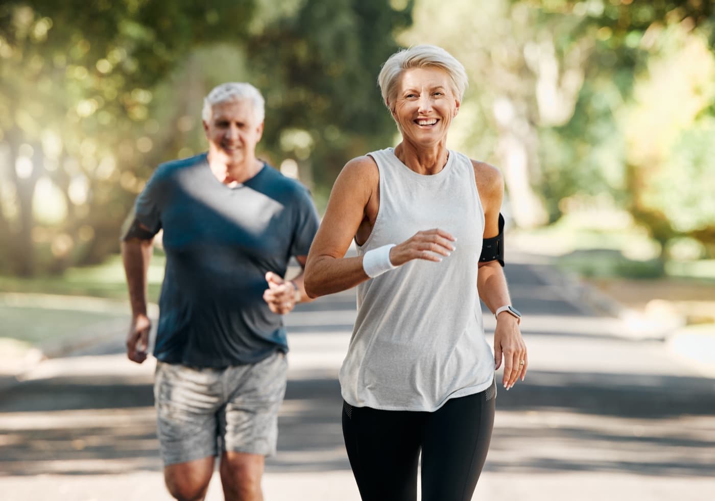 An active senior couple jogging together outdoors